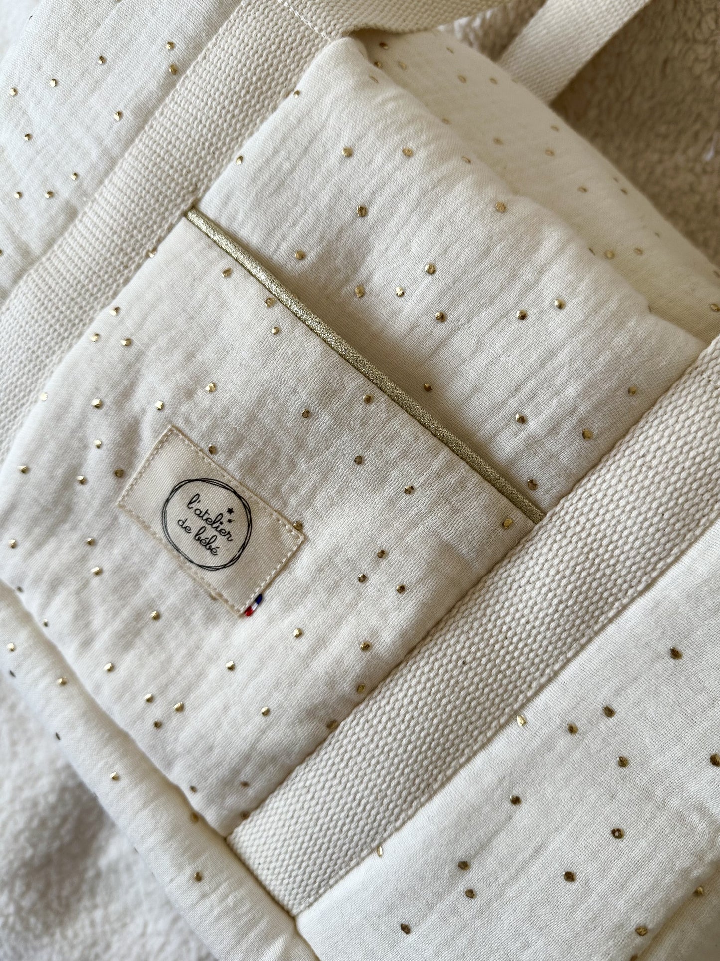 ZOOM SUR LA POCHE EXTERIEUR DU SAC MINI ,PASSEPOIL DORÉ ET ETIQUETTE DE LA MARQUE